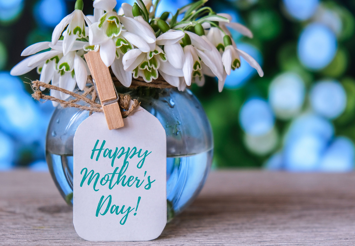 Happy Mothers Day greeting card, along with spring flowers in a vase
